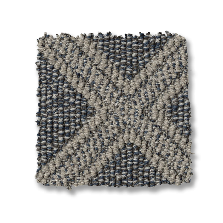 Scout Pet Friendly Carpet features a square, textured swatch with a gray and blue geometric X-shaped pattern. Its chunky, looped weave offers durability and style, making it ideal for homes with pets.