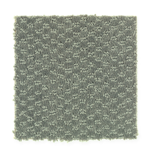 A square swatch of Dynamo Family Friendly Carpet in Turf, featuring gray textured fabric with a subtle geometric pattern, is displayed on a white background.