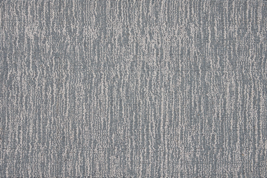 Close-up of the Effervescense On Trend Carpet in Azure, featuring irregular vertical white lines on a blue-gray background for a modern, abstract look with contemporary elegance.