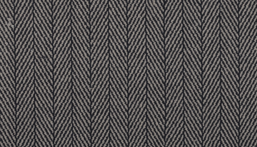 Close-up of the Eastleigh Berber Carpet in Filigree, showcasing a luxurious herringbone pattern in gray and black with repeating V-shaped lines—ideal for adding stylish durability to high-traffic areas.