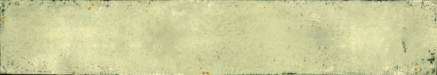 The Eclipse 2x18 Glazed Porcelain Tile features a distressed, vintage look with frayed edges and a faded yellow tint, along with dark stains that echo the character of an aged architectural piece.