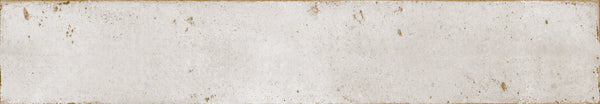 Featuring a rectangular, textured surface with distressed details, Eclipse 2x18 Glazed Porcelain Tile has an off-white finish with brown stains, scratches, and worn edges that evoke vintage architectural tile.