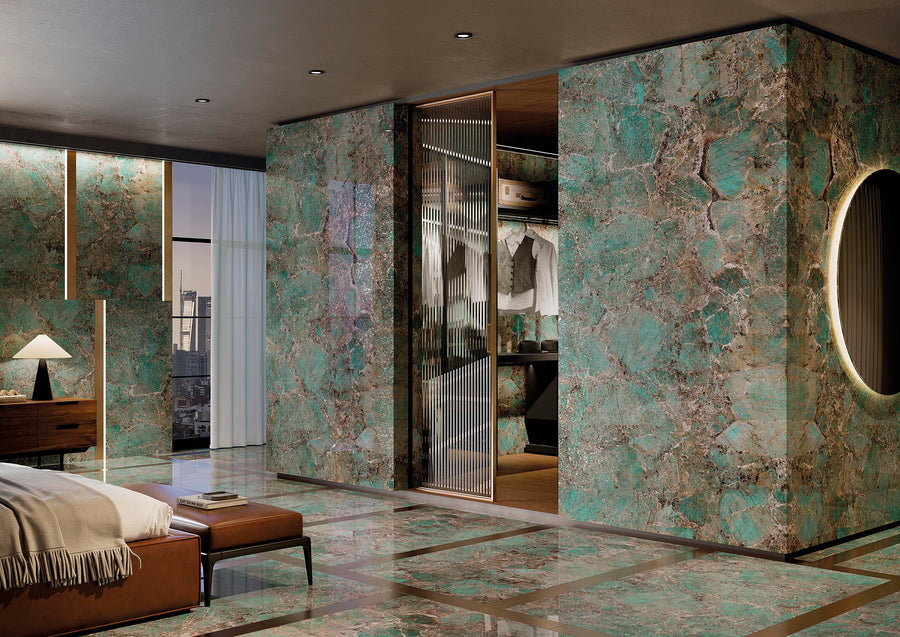 Luxurious bedroom with polished green marble walls and floor, a round backlit mirror, glass closet doors, wooden furniture, and city view through large windows. The space is modern and elegant.