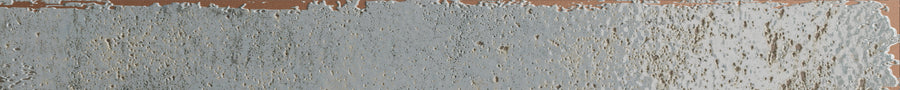 A close-up of the Emerge 2x20 Porcelain Tile in Aurora color, showcasing its textured surface with light blue-gray tones and brownish undertones for an uneven, weathered look.