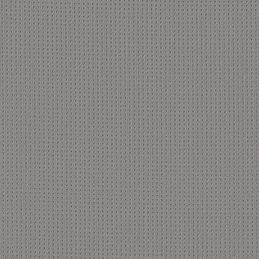 Close-up of San Lucas Family Friendly Carpet in Essential color, featuring a textured gray vertical ribbed pattern with evenly spaced stitches—ideal for busy, high-traffic homes.