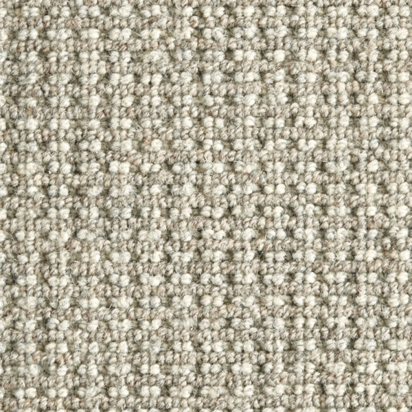 Close-up view of Timbers Berber Carpet in Etched Pewter, featuring a textured loop-pile and subtle woven pattern. Its tightly packed fibers provide a soft feel and durable finish, perfect for contemporary flooring.