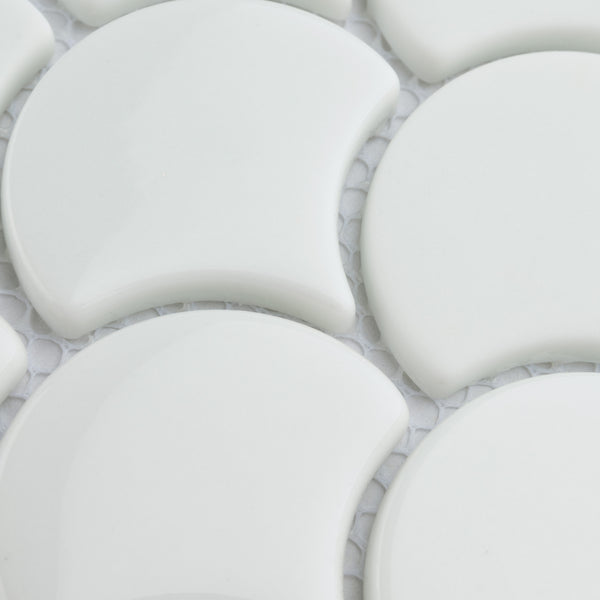 Close-up of white, crescent-shaped ceramic tiles arranged in a repeating pattern on a white mesh backing. The tiles have a glossy finish and smooth surface.