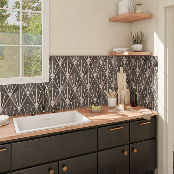 A modern kitchen with black cabinets, wooden countertops, a white sink, geometric black-and-white backsplash, and open wooden shelves holding plants and kitchenware. Sunlight streams in through a window above the sink.