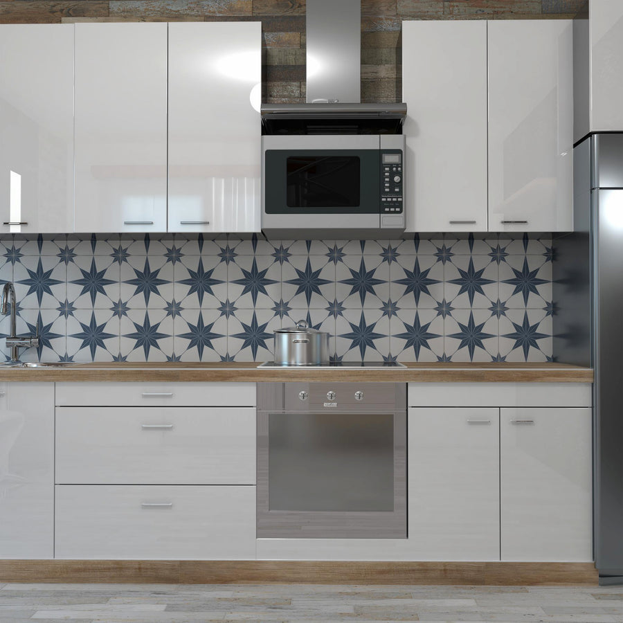 Modern kitchen with glossy white cabinets, wooden countertops, geometric blue-and-white star pattern backsplash, stainless steel oven, microwave, and refrigerator. A pot is on the stove beneath the microwave.