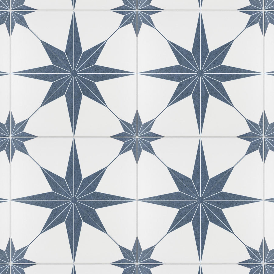 White tiles with a repeating pattern of large and small navy blue eight-pointed stars, creating a geometric and symmetrical design. The stars are evenly spaced and interconnected.