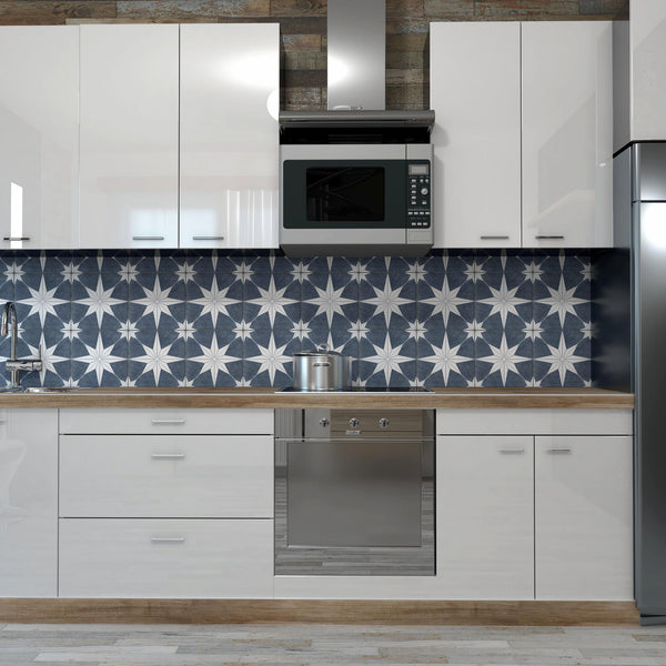 Modern kitchen with glossy white cabinets, stainless steel appliances, a wood countertop, and a stove. The backsplash features a bold dark blue and white geometric star pattern. A silver microwave is mounted above the stove.