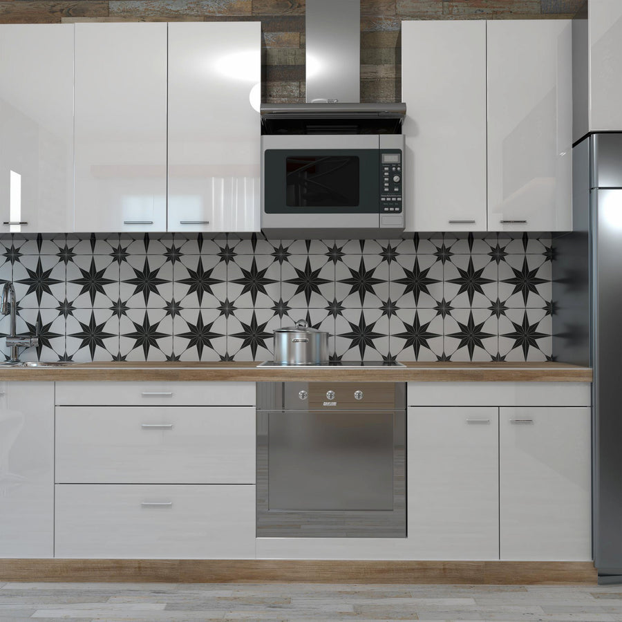 Modern kitchen with glossy white cabinets, wood countertops, a stainless steel oven, microwave, and refrigerator. The backsplash features a bold black and white geometric star pattern.