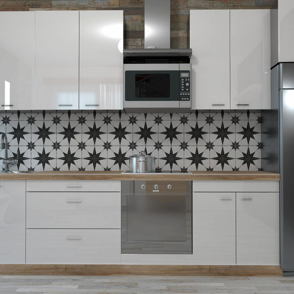 Modern kitchen with glossy white cabinets, wood countertops, a stainless steel oven, microwave, and refrigerator. The backsplash features a bold black and white geometric star pattern.