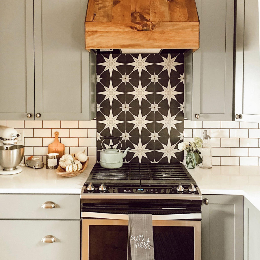 A kitchen with a stove and a wooden hood.