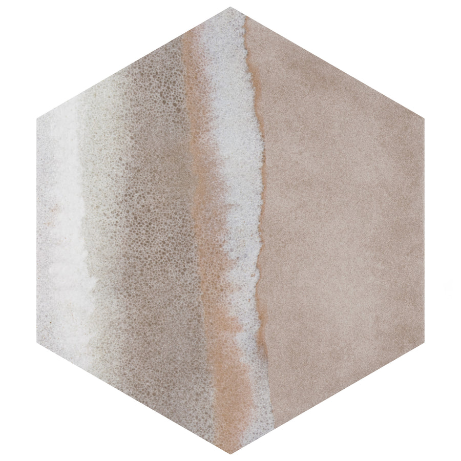Hexagonal tile with a pattern resembling a sandy beach, featuring beige and tan tones with a white, foamy strip running diagonally, mimicking waves meeting the shore.