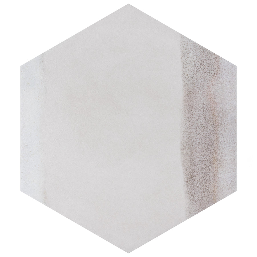 A hexagonal tile with a mostly smooth, light beige surface and a subtle textured brownish area along the right edge.