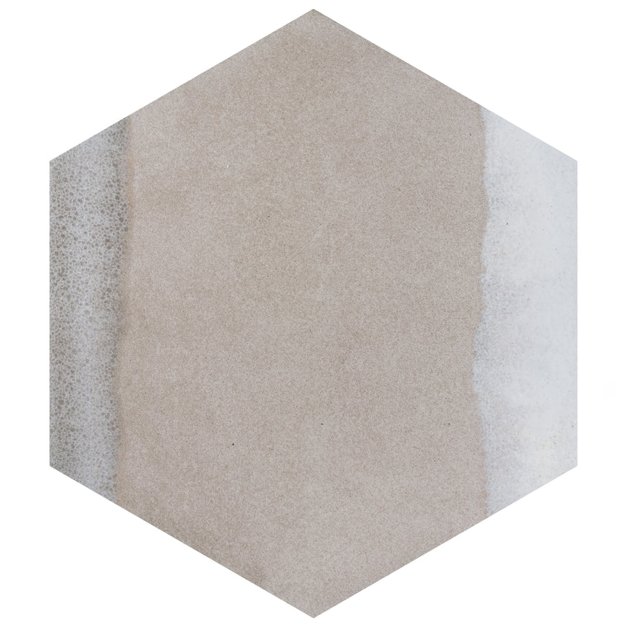 A hexagonal tile with a beige center and irregular white and gray shading along the left and right edges. The surface has a slightly textured, matte appearance.