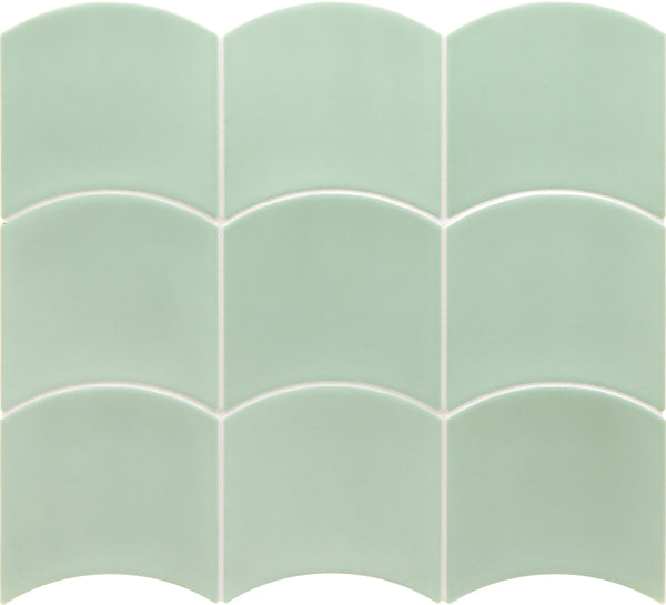 Flow Motion 5x5 Glazed Ceramic Tiles in light green, each with a unique scallop shape, are arranged in three rows of four and separated by crisp white grout lines.