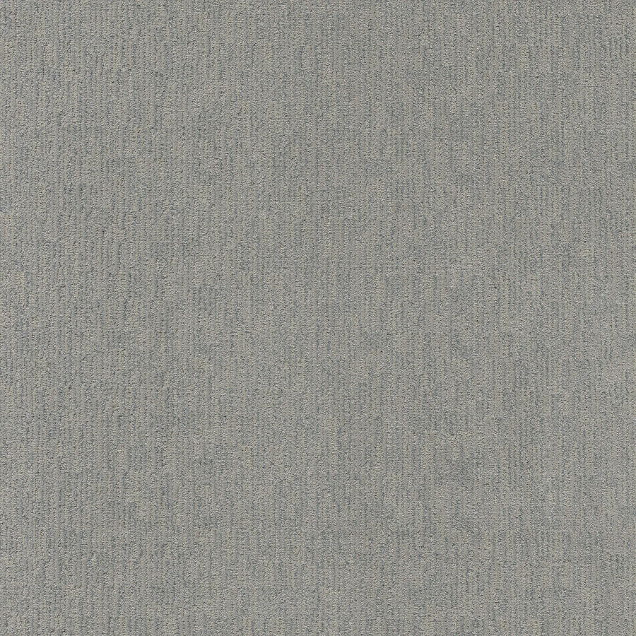 A close-up of Sneak Peak Berber Carpet in Fresh Tone shows its textured, light gray surface with a subtle linear pattern. The dense pile offers both softness and durability, highlighting slight shade and texture variations.