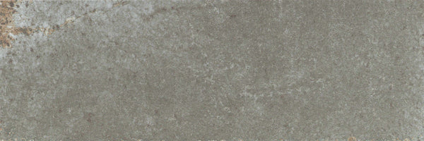 A close-up of the Catalyst 4x12 Porcelain Tile in Fuse Grey, showcasing its textured stone surface with subtle brown and white accents and natural slate-like patterns.