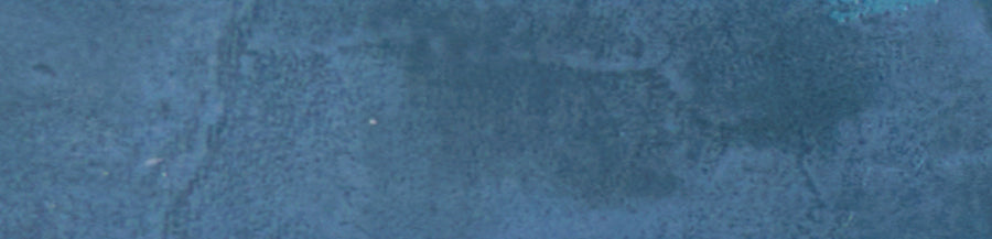 A close-up of the Galaxy 2x10 Porcelain Tile reveals a textured blue surface with subtle color variations and faint patches, showcasing the unique glazed finish.