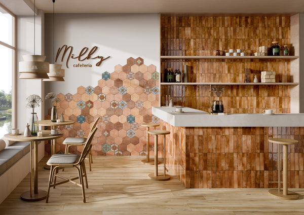 A cozy café interior with wooden tables and stools, a counter, open shelves with jars and cups, and a wall decorated with hexagonal tiles and a sign reading Milky cafetería. Large windows let in natural light.