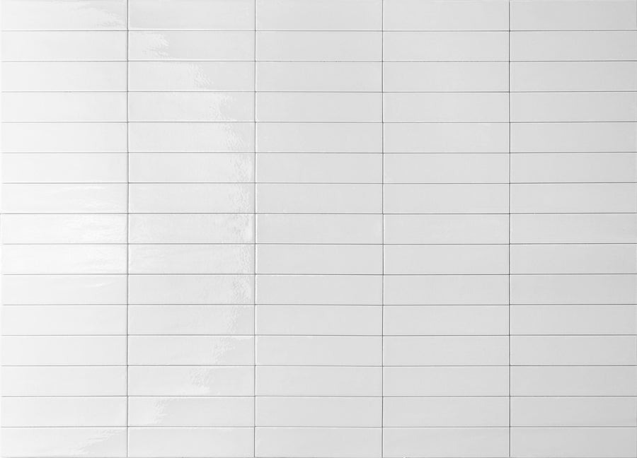 A grid of glossy white rectangular tiles arranged in rows and columns, with visible grout lines between each tile. The surface reflects light, creating subtle highlights and a clean, minimalistic appearance.