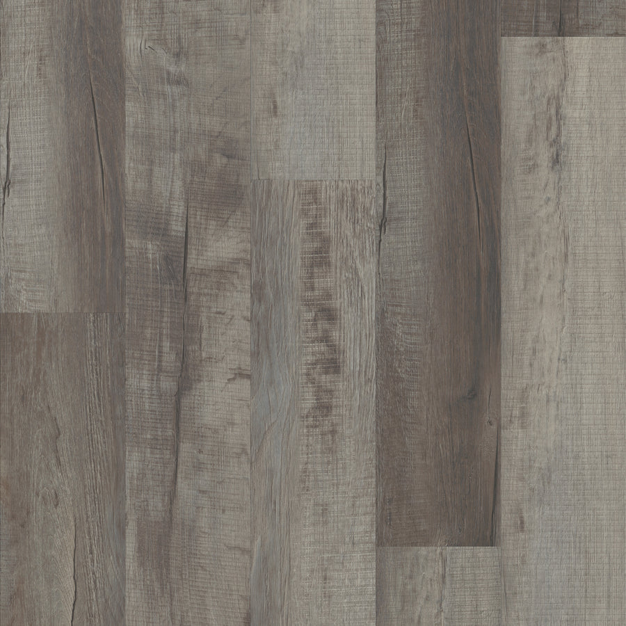 A close-up of rustic, weathered wooden floor planks in brown and gray tones highlights natural grain patterns—ideal for those wanting luxury flooring with the durability of Coretec Pro Plus Vinyl’s rigid core construction.