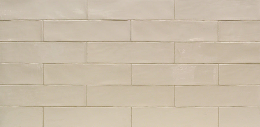 The Masia 3" x 12" Ivory Subway Tile features an off-white hue and a glossy finish, with slight surface variations. Laid in a horizontal brick pattern, it creates clean, simple accent walls or kitchen backsplashes with added visual interest.
