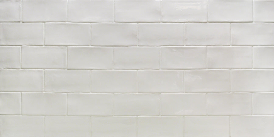 A close-up of a wall featuring Masia 3" x 6" Subway Tile in Blanco, arranged in a classic horizontal brick pattern with visible grout lines—perfect for a kitchen backsplash.