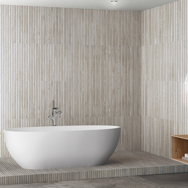 A modern bathroom with a white freestanding bathtub, wall-mounted faucet, and vertical beige striped tiles. There is a built-in wooden shelf on the right and minimalist decor.