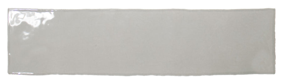 The Bali 3x12 Ceramic Subway Tile features a glossy, light gray finish and subtly uneven edges, displayed on a white background, offering an elegant luxury style to any space.