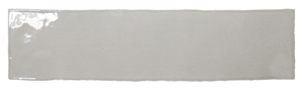 The Bali 3x12 Ceramic Subway Tile features a glossy, light gray finish and subtly uneven edges, displayed on a white background, offering an elegant luxury style to any space.