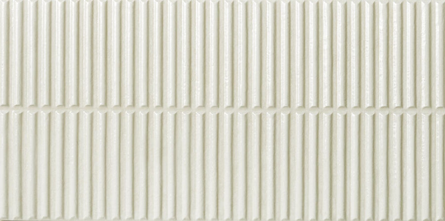 A close-up of the Dunes 12x24 Porcelain Tile shows its light, off-white textured surface with vertical ridges and a horizontal split—perfect for backsplashes or feature walls.