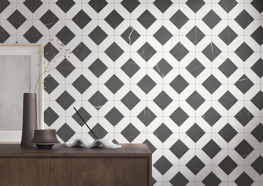 A modern interior with a geometric black-and-white tile wall, and a wooden table holding minimalist decor including a vase, framed art, incense sticks, and a sculpted tray.