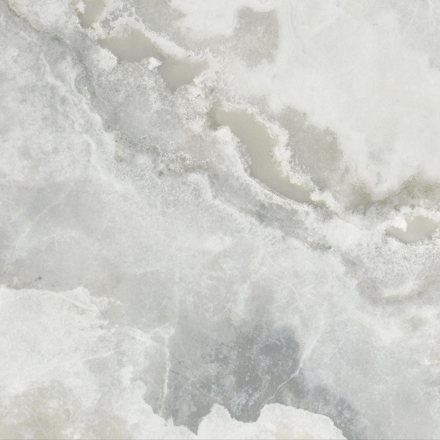 A close-up of the Monaco 12x12 Glazed Porcelain Tile shows its light gray and white marble-like surface with natural, cloudy patterns and subtle veins. Its smooth texture and blended shades make it perfect for stylish flooring.