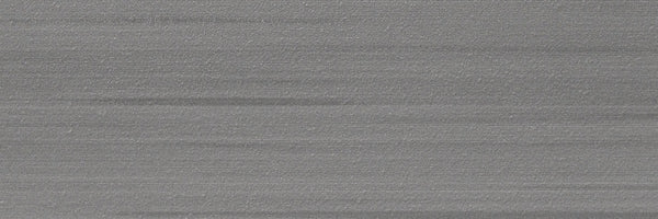 A close-up of the Met 4x12 Porcelain Tile reveals its silvery-grey brushed metal look with horizontal lines, subtle textures, and gradients—ideal for modern spaces embracing contemporary design trends.
