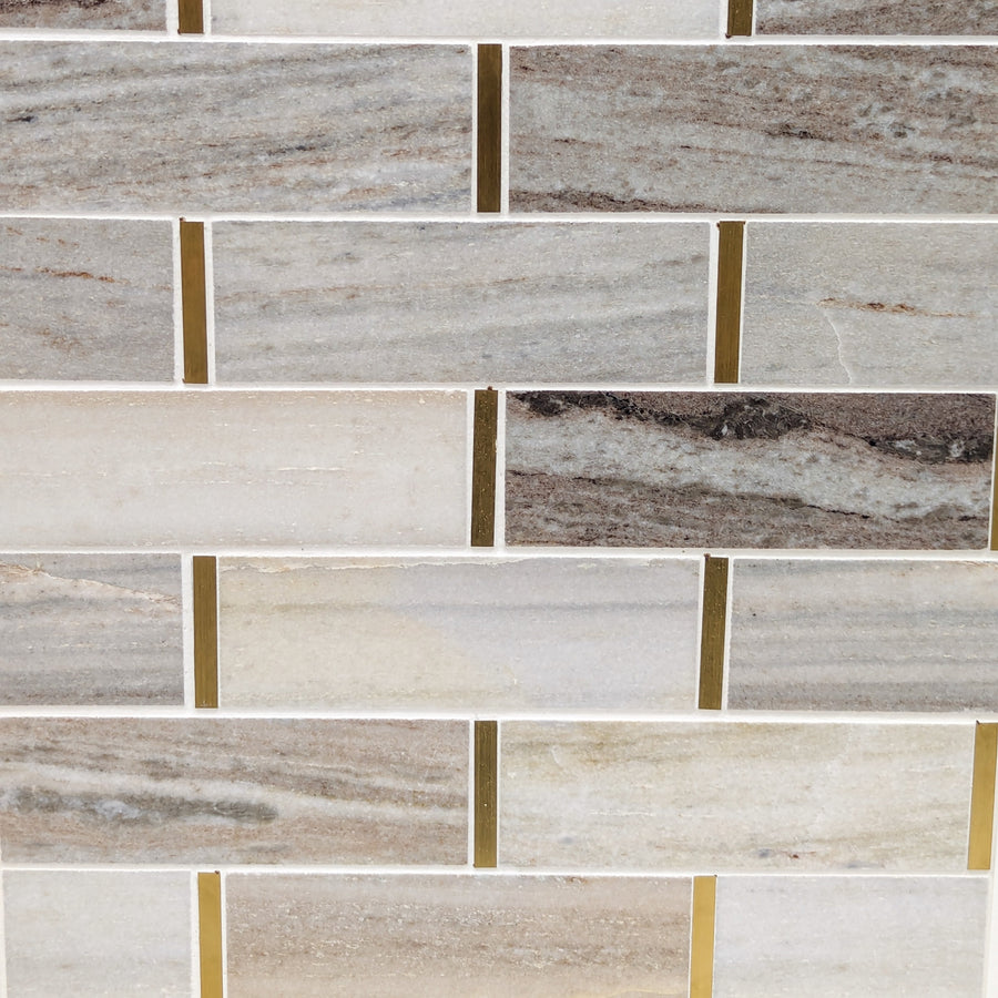 The Glam Brick Palisandro Polished Marble Mosaic Tile features rectangular beige, gray, and tan tiles in a staggered pattern, separated by thin brass accents for a metallic touch.