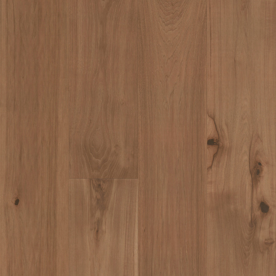 Close-up of Gran Reserva 7 1/2" Hardwood in the color Decant, showcasing wide planks with prominent natural wood grain patterns, knots, and gentle color variations. The smooth, polished surface enhances its luxurious appearance.