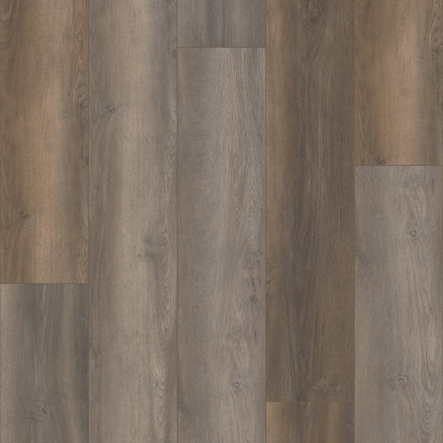 Close-up of Coretec Plus Premium Vinyl flooring planks in varying brown and gray shades, featuring natural wood grain patterns and smooth texture, arranged in a staggered layout.