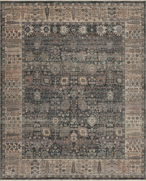 The Echo Area Rug features detailed floral and geometric motifs in blue, gray, beige, and brown, with a wide decorative border encircling an intricate central panel.