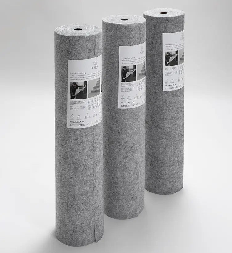 Three large rolls of Guardia Surface Protection, each upright on a white surface. Every roll features a white label with images and text on the front.