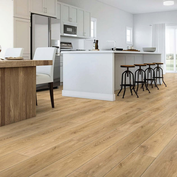 A modern kitchen and dining area with light wood flooring, white cabinets, an island with bar stools, a dining table with white chairs, and large windows letting in natural light.