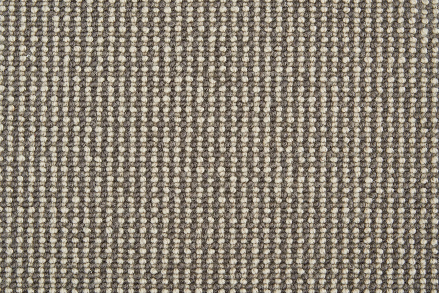 Close-up of Harper Berber Carpet in Gun Metal, showing a textured woven pattern with alternating beige and gray threads for a grid-like, durable surface—blending everyday resilience with timeless style.