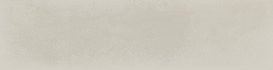 The Harmony 2.5x10 Porcelain Tile features a textured, light beige surface with subtle tonal variations, reminiscent of watercolor paper and handmade tile for a delicate artisanal look.