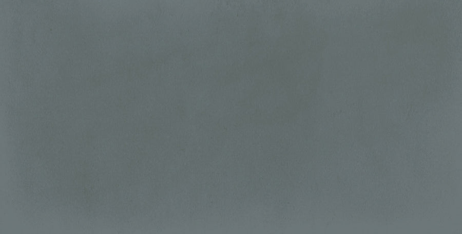 The Harmony 2.5x5 Porcelain Tile features a textured matte gray-blue surface with subtle shading, resembling painted or concrete material and bringing unique character to any space.