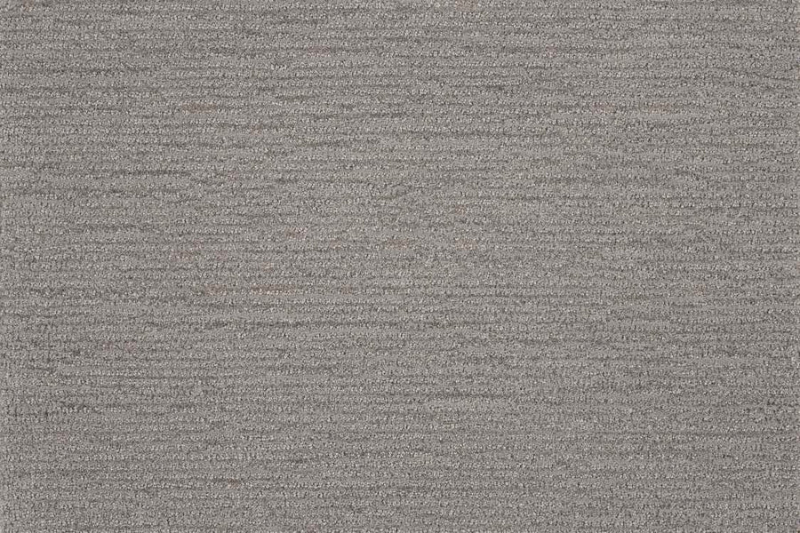 Close-up of Highlands Berber Carpet in Canyon, featuring a textured surface with a subtle horizontal weave and fine threads. This contemporary flooring offers stylish shading variations and a comfortable feel underfoot.