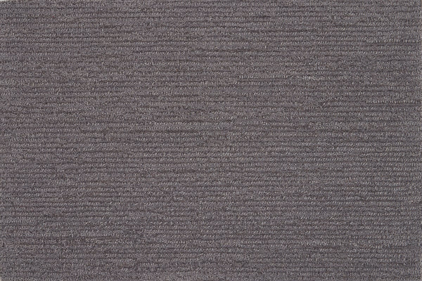 Close-up of Highlands Berber Carpet in Carbon color, showing its textured surface with horizontal ridges. This durable flooring features soft, densely packed fibers and a subtle striped look for a comfortable feel underfoot.