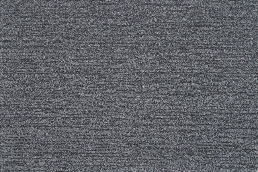 Close-up of Highlands Berber Carpet in Mineral—a textured dark gray carpet with subtle horizontal lines and a slightly mottled pattern, providing contemporary, comfortable flooring.