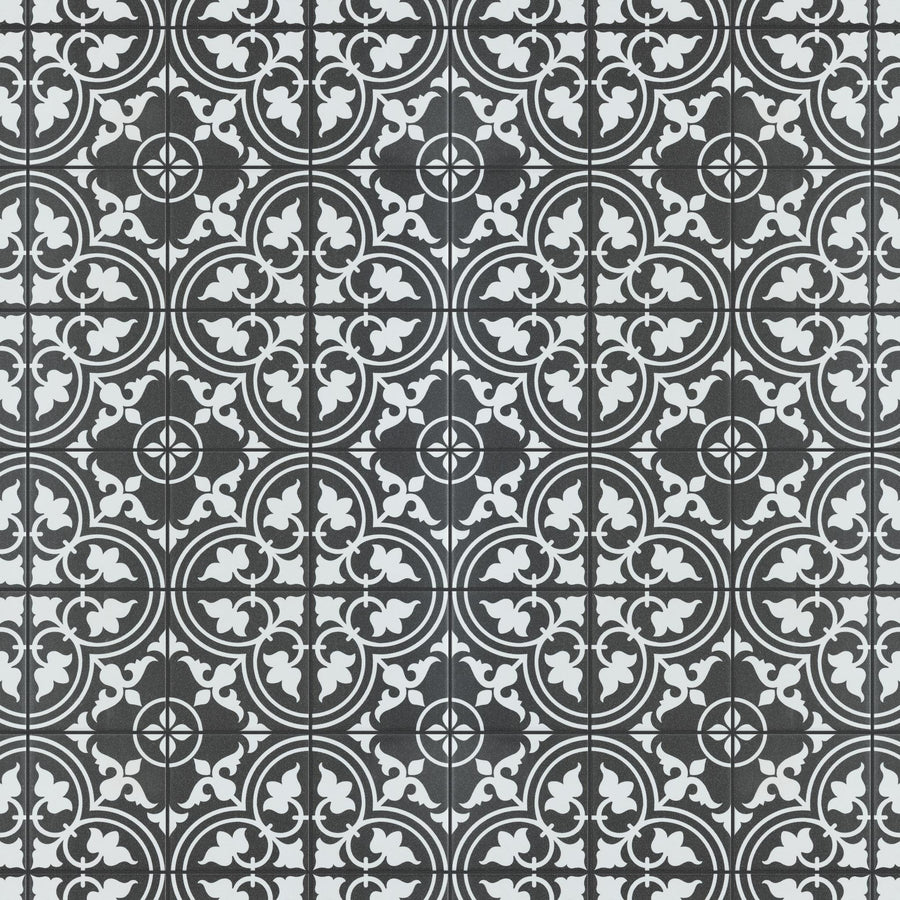 Black and white decorative tile pattern with repeating circular floral and geometric motifs, separated by thin black grid lines forming squares. The design creates an intricate, symmetrical, and vintage appearance.